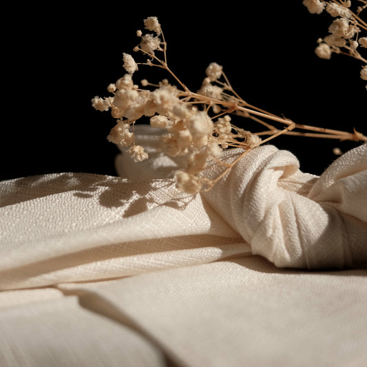 Dried flowers on a textured beige furoshiki cloth with a dark background