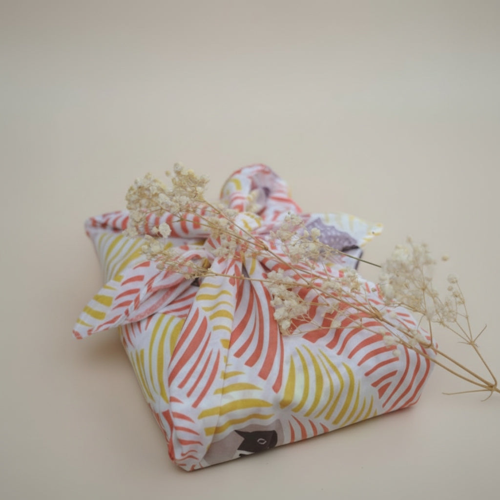 Colorful fabric bundle with dried flowers on a beige background