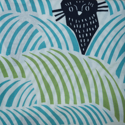 Close-up of a furoshiki cloth with birds and cats on a blue and green background