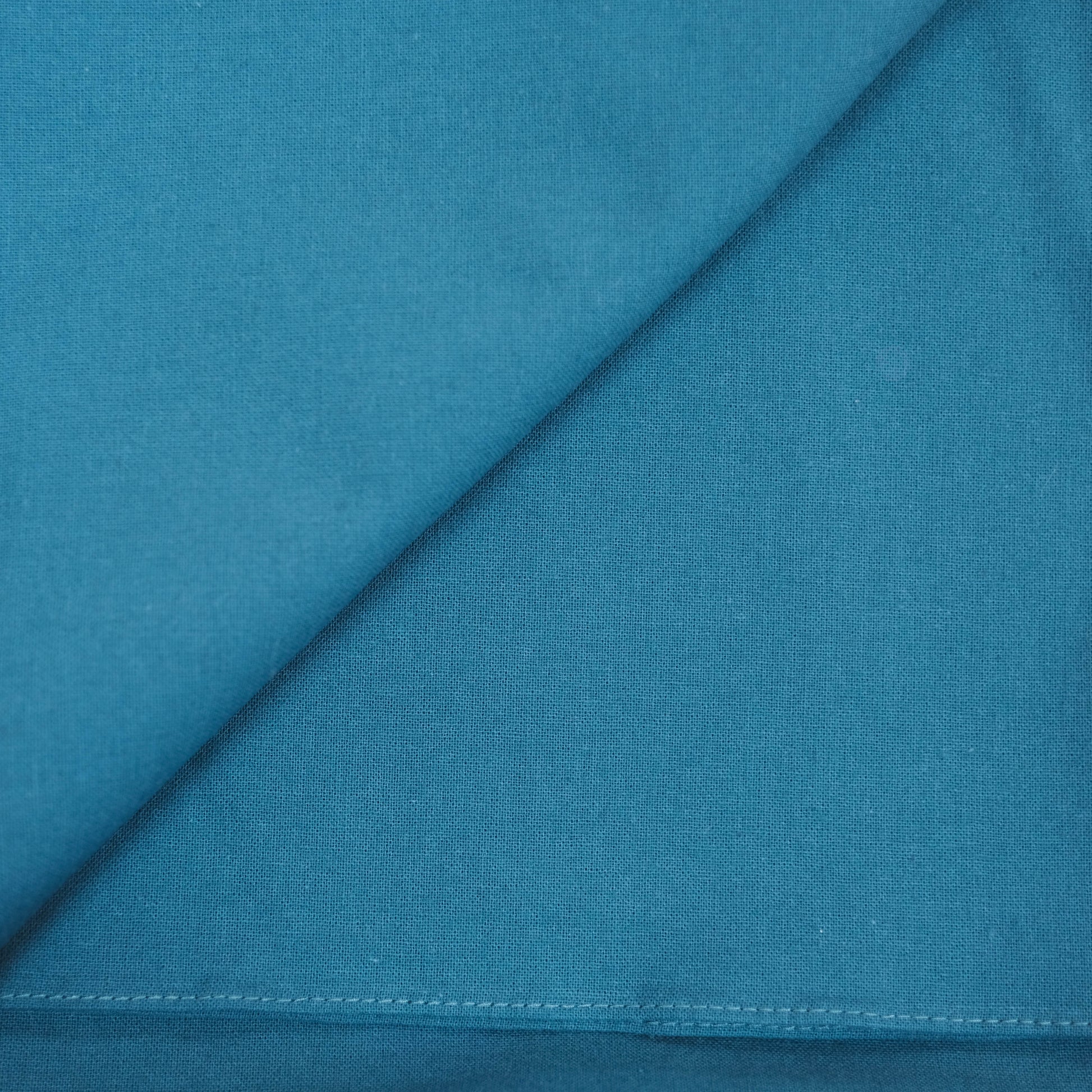 Teal furoshiki fabric with a diagonal seam and stitching detail