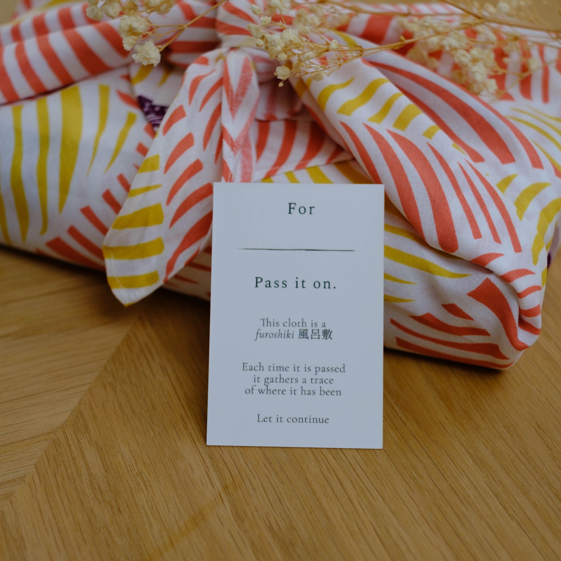 Colorful fabric with a message card on a wooden surface