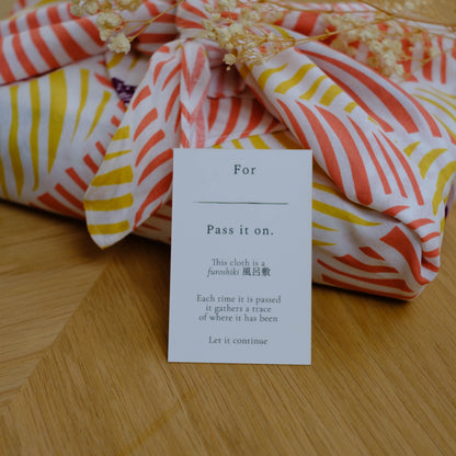Colorful fabric with a message card on a wooden surface