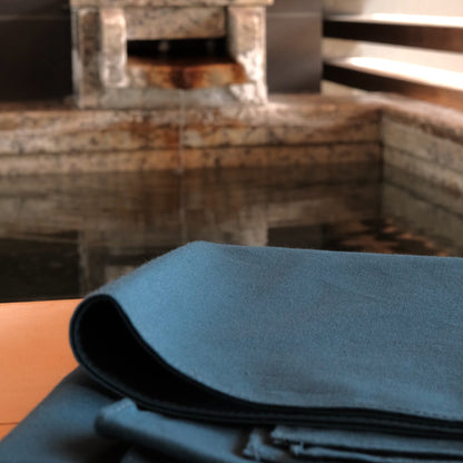 Folded blue fabric on a wooden surface with a blurred background