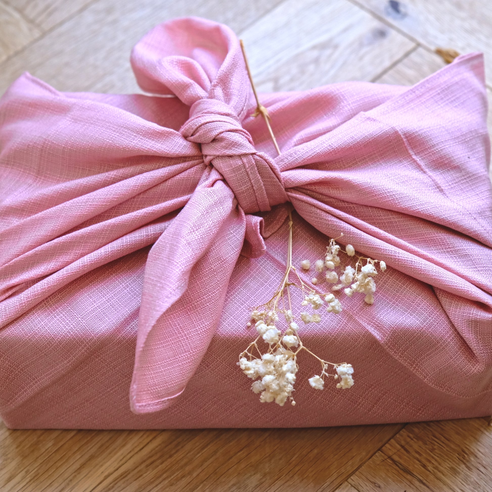 A close up of a pale smoky pink furoshiki gift cloth
