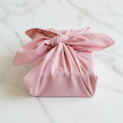 Pink fabric bundle on a white marble surface